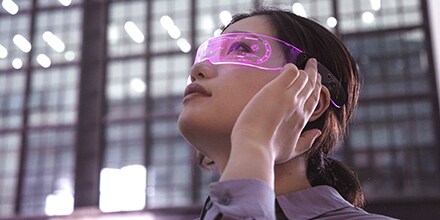 Woman with high-tech glasses gazes upward.