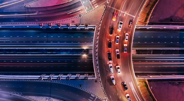 Overhead view of cars on curving highway.