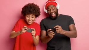 Two gamers playing a game on their phones.