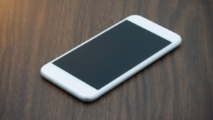 A white iPhone sitting on a table being traded in.