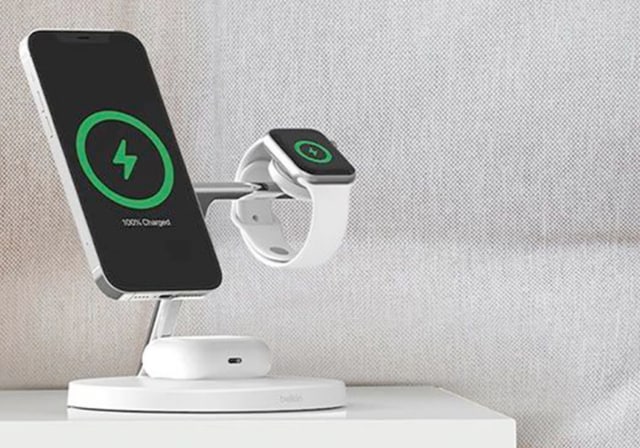 A wireless charger on a nightstand, charging a smartphone and smartwatch.