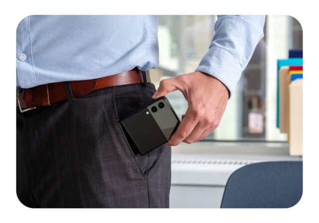 A man placing a Samsung Galaxy Z Flip phone in his pocket.
