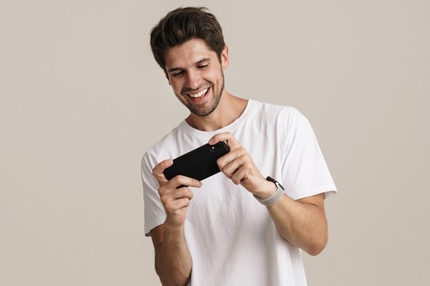 A man holding a cell phone enjoying mobile entertainment