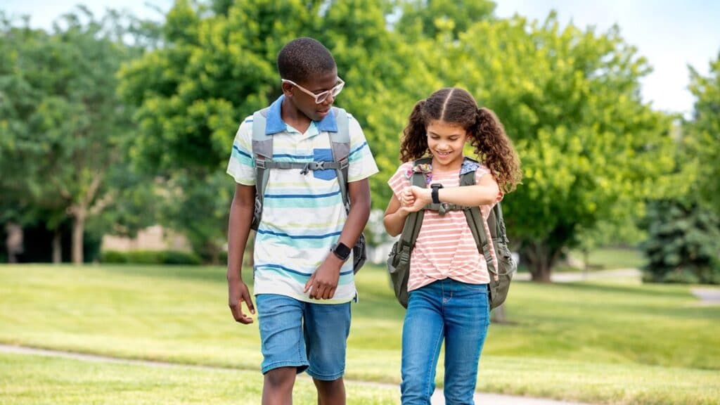 Two children walking while wearing their SyncUP KIDS watches.
