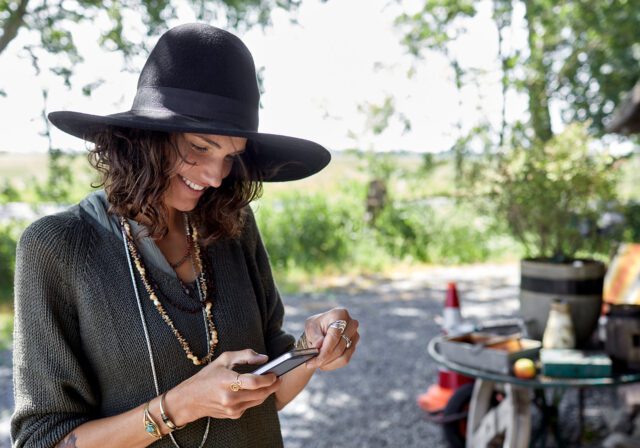 A person working outdoors using satellite phone service.