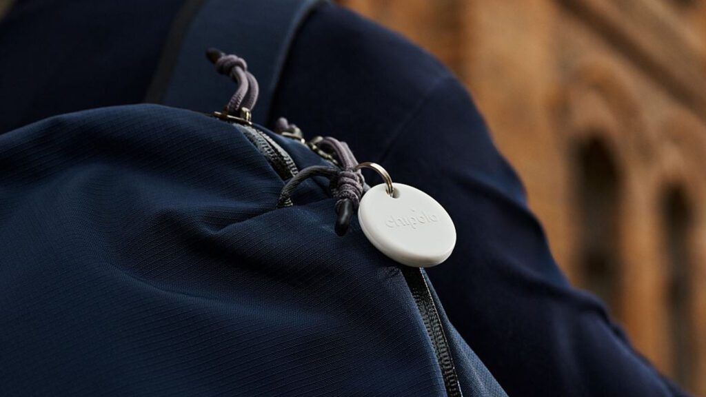 Image of a Chipolo POP Tracker Tag hanging off a blue backpack.