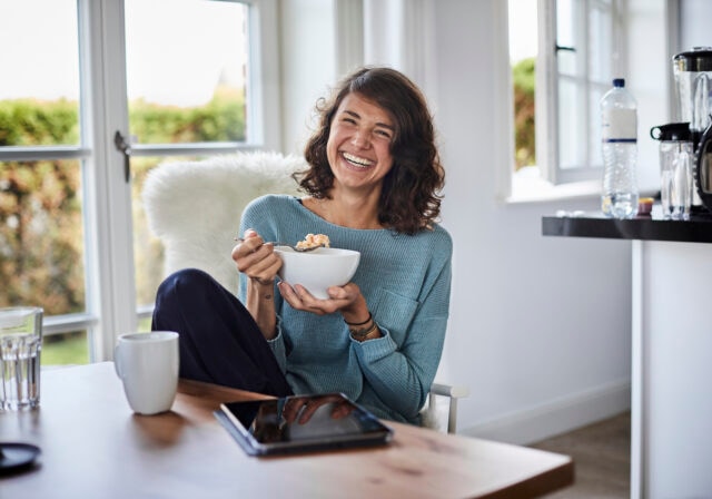 woman-having-breakfast-dining-table-off-tablet