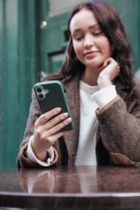 Woman-using-iPhone-16-at-table