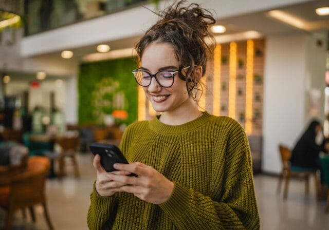 woman-smiling-at-screen-on-smartphone
