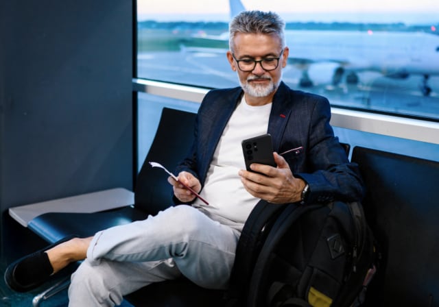 Man-checking-his-phone-in-airport