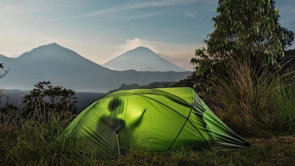 Image of a person using a tablet while inside a tent.