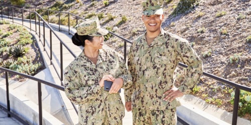 two servicemembers in uniform smiling
