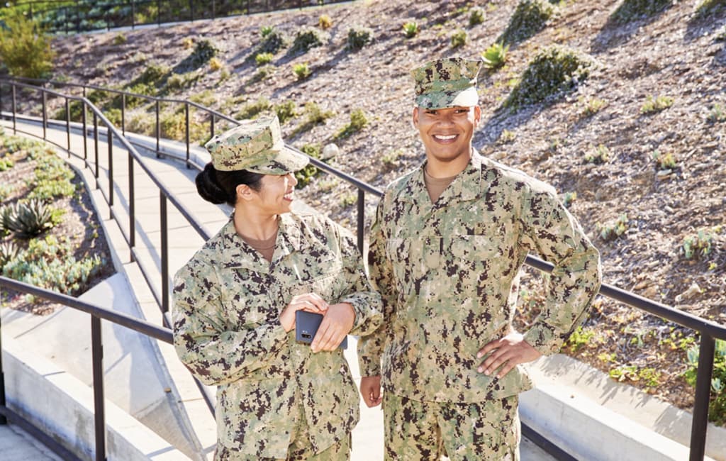 two servicemembers in uniform and smiling