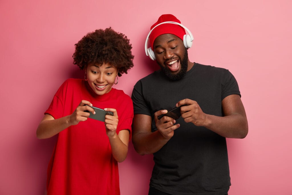Woman and man playing video games on cell phones