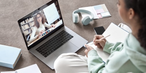 Girl sitting on the floor in front of her laptop