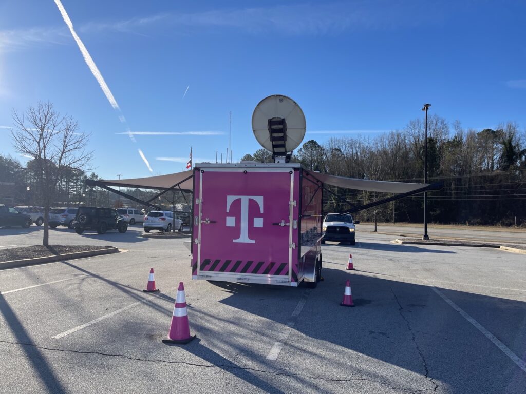 T-Mobile branded emergency response truck in an open parking lot with blue skies. 