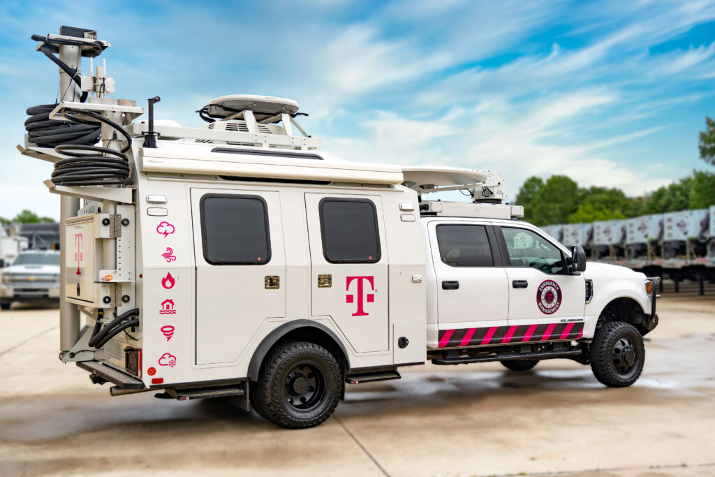 Camioneta con el logotipo de T-Mobile tiene varios íconos relacionados con el clima. El equipo satelital del vehículo está replegado para mostrar su portabilidad y está estacionado al aire libre