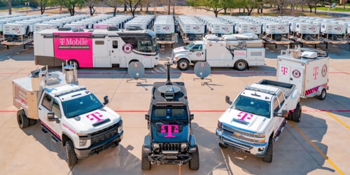 Large fleet of heavy-duty emergency vehicles and portable generators all branded with the T-Mobile logo.