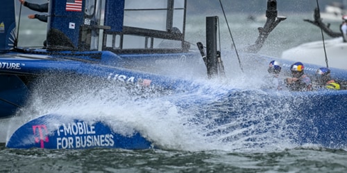 A sailboat with the T-Mobile for Business races through the water.