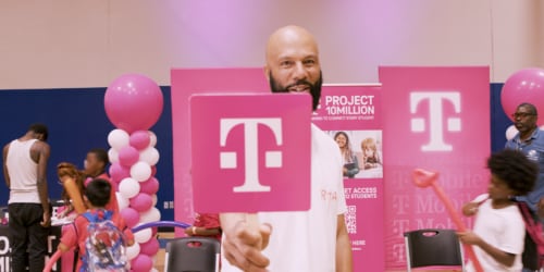 Rapper Common holding a T-Mobile fan