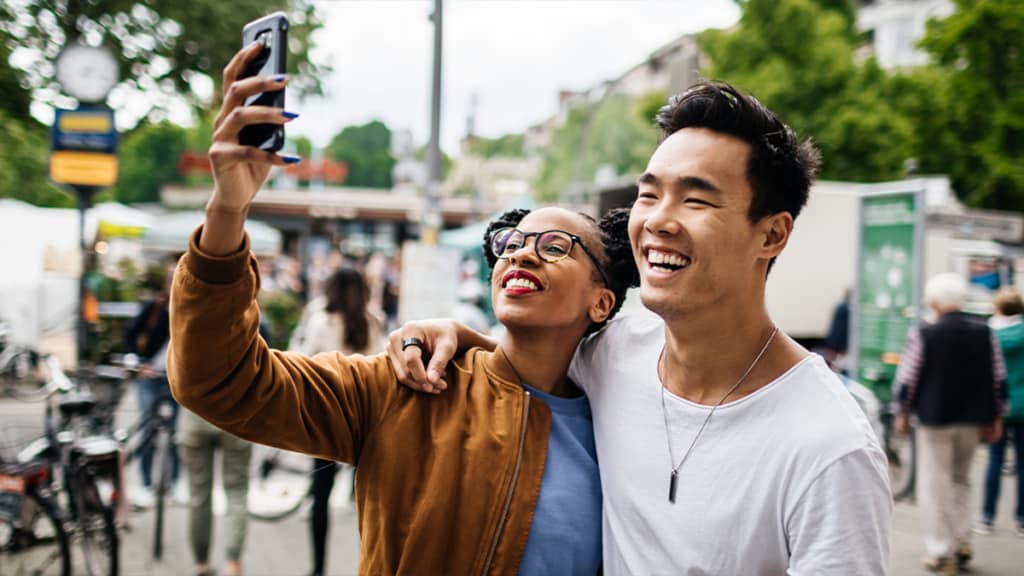 A couple takes a photo with a smartphone
