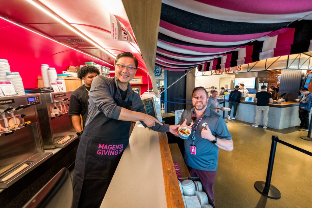 John Saw, EVP, Chief Technology Officer at T-Mobile, hands off a cup of froyo with a smile