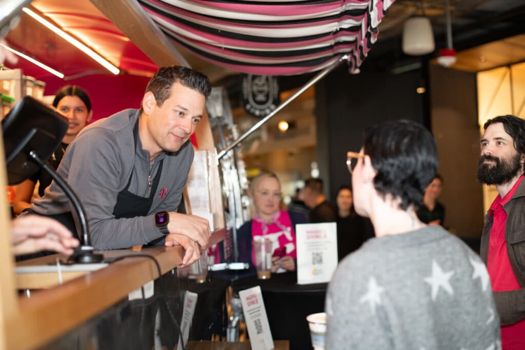 Mike Katz, President of Marketing, Strategy and Products at T-Mobile, chats with employees at the Froyo for Good airstream