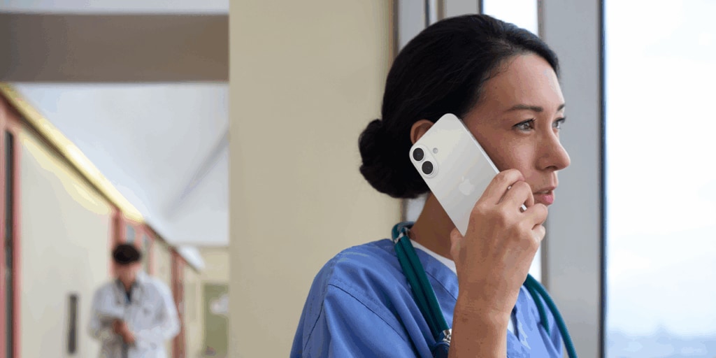 Woman speaks on iPhone while looking out the window