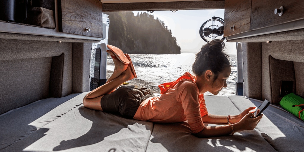 Woman texts on an iPhone from a boat on the water