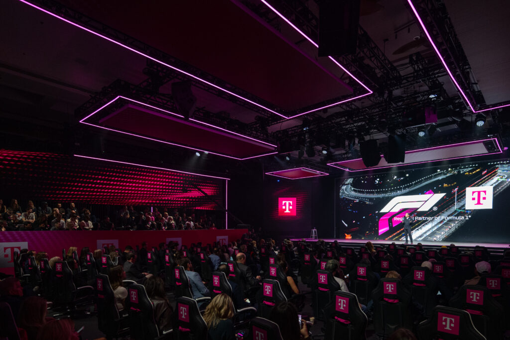 T-Mobile President and CEO, Srini Gopalan, unveils the company's latest news on stage at ARIA Resort and Casino during the Formula 1 Las Vegas Grand Prix on Nov. 20, 2025. T-Mobile announced Switching Made Easy, making switching providers easy, fast and smart, with new AI-powered plan matching, the freedom to get a new phone later, and same-day device delivery via DoorDash. (Brian Friedman/AP Content Services for T-Mobile)