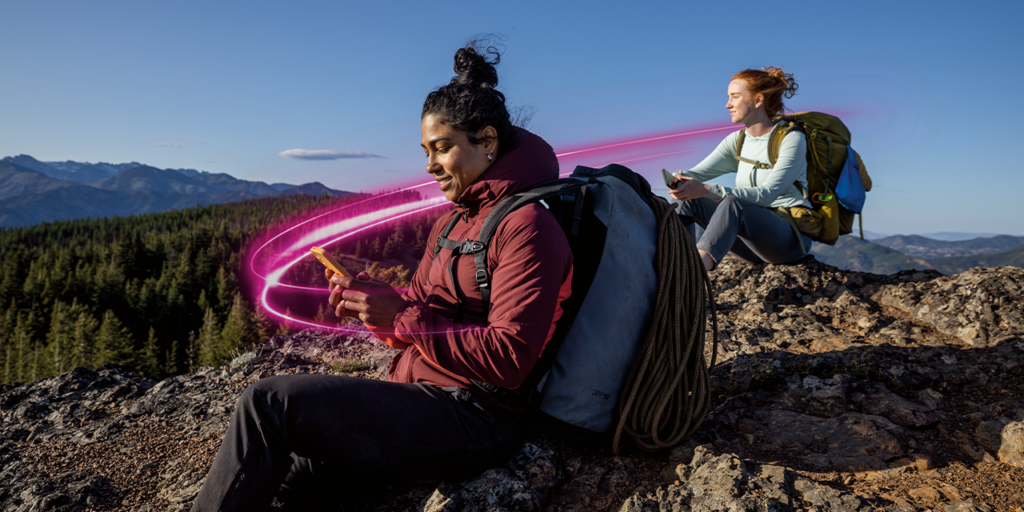 Two hikers enjoying a break while they are on their phones. There is a magenta beam circling around them highlighting T-Mobile coverage and T-Satellite availability.
