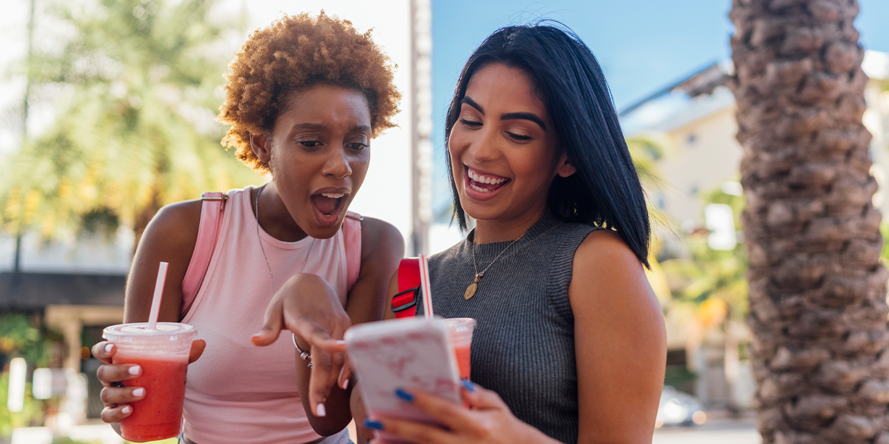Two women smiling while looking at a phone